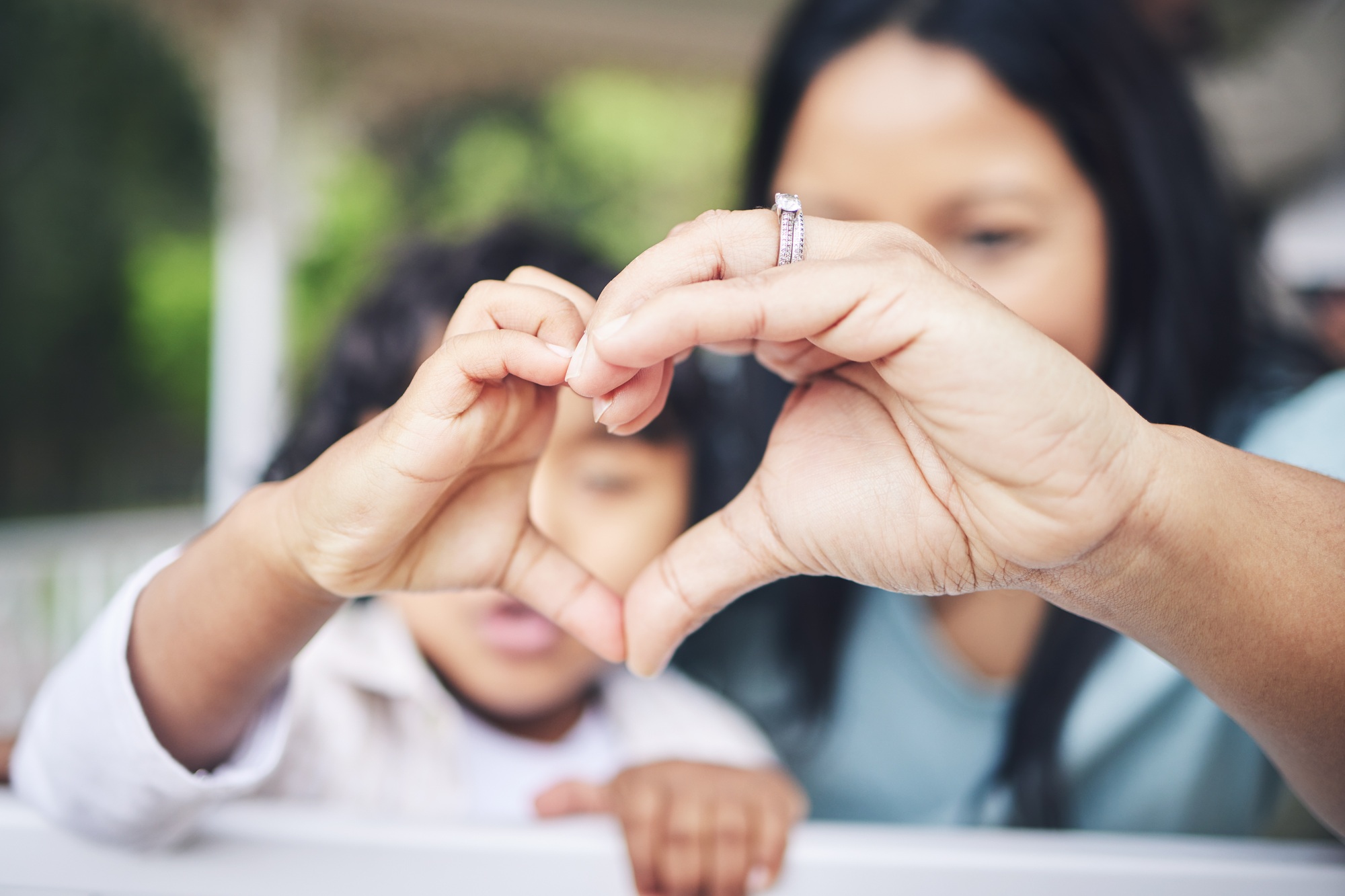 Mother, child and heart hands for love, care or compassion together in the outdoors. Mom and little
