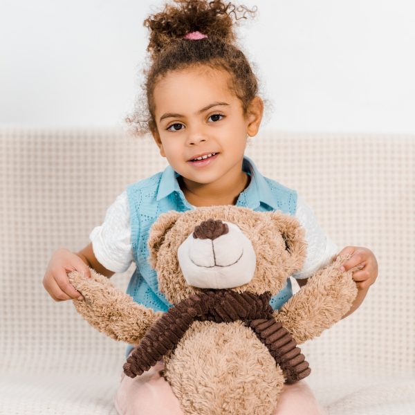 beautiful happy african american child holding teddy bear and smiling at camera beautiful happy african american child holding teddy bear and smiling at camera
